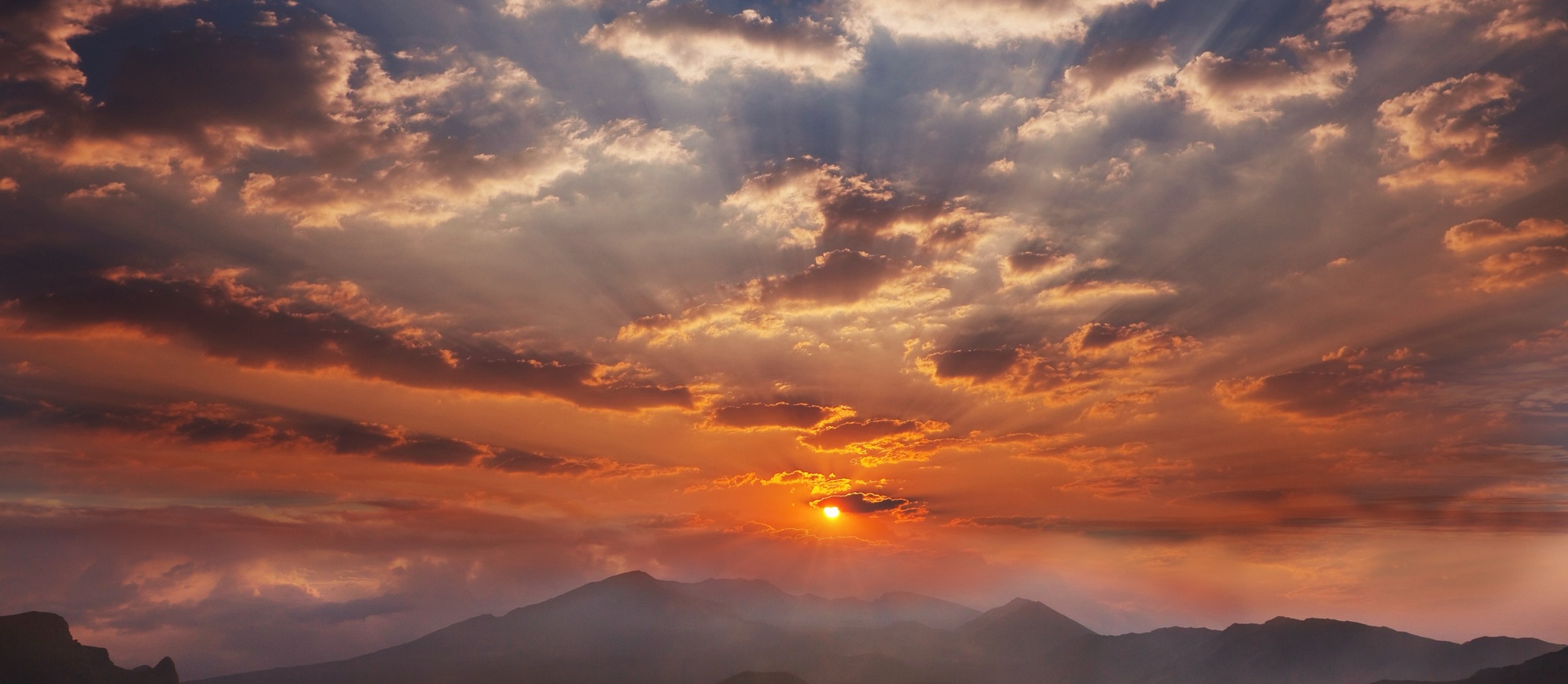 Sunrise breaking over the Appalachian mountains, golden light spreading through clouds